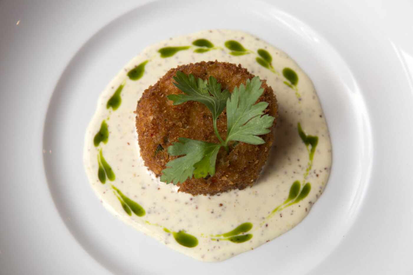 Crab cake with lemon mustard sauce and parsley oil
