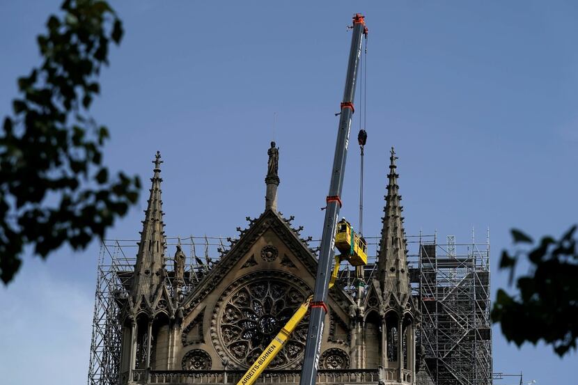 Workers cover and protect the rosette seven days after a fire devastated the cathedral. 
