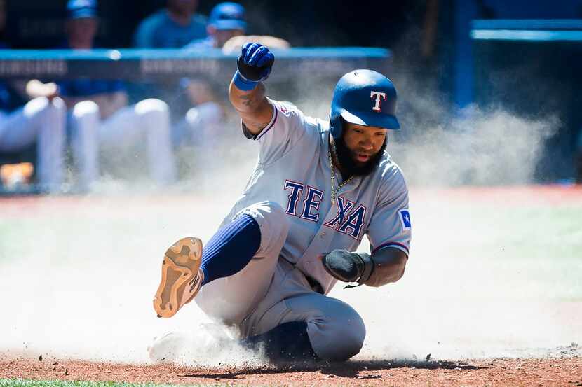 Texas Rangers' Danny Santana scores against the Toronto Blue Jays during the sixth inning of...