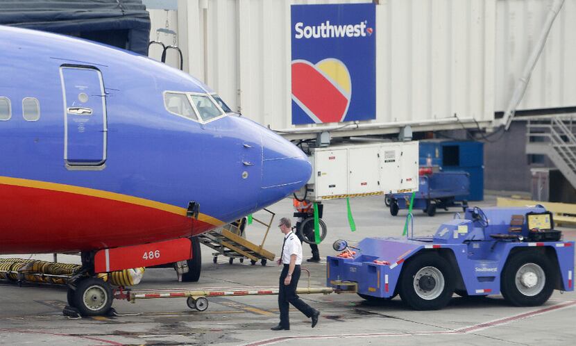 A Southwest Airlines pilot performs a pre-flight check on an aircraft at Hartsfield...