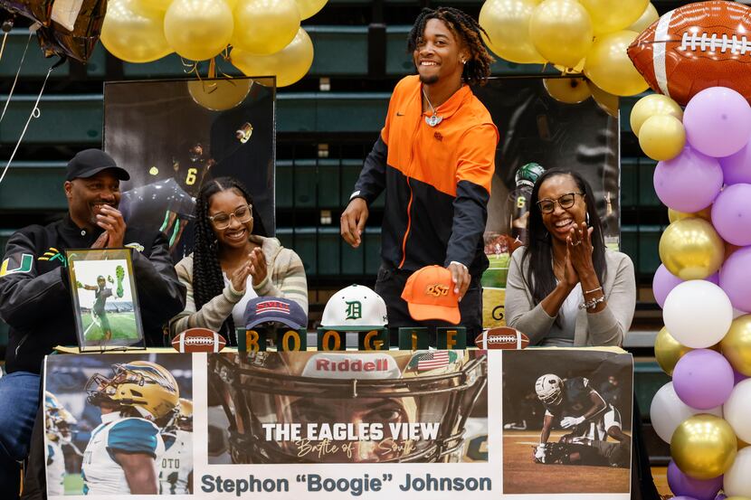 DeSoto wide receiver Stephon Johnson, second from right, reaches for the Oklahoma State cap...