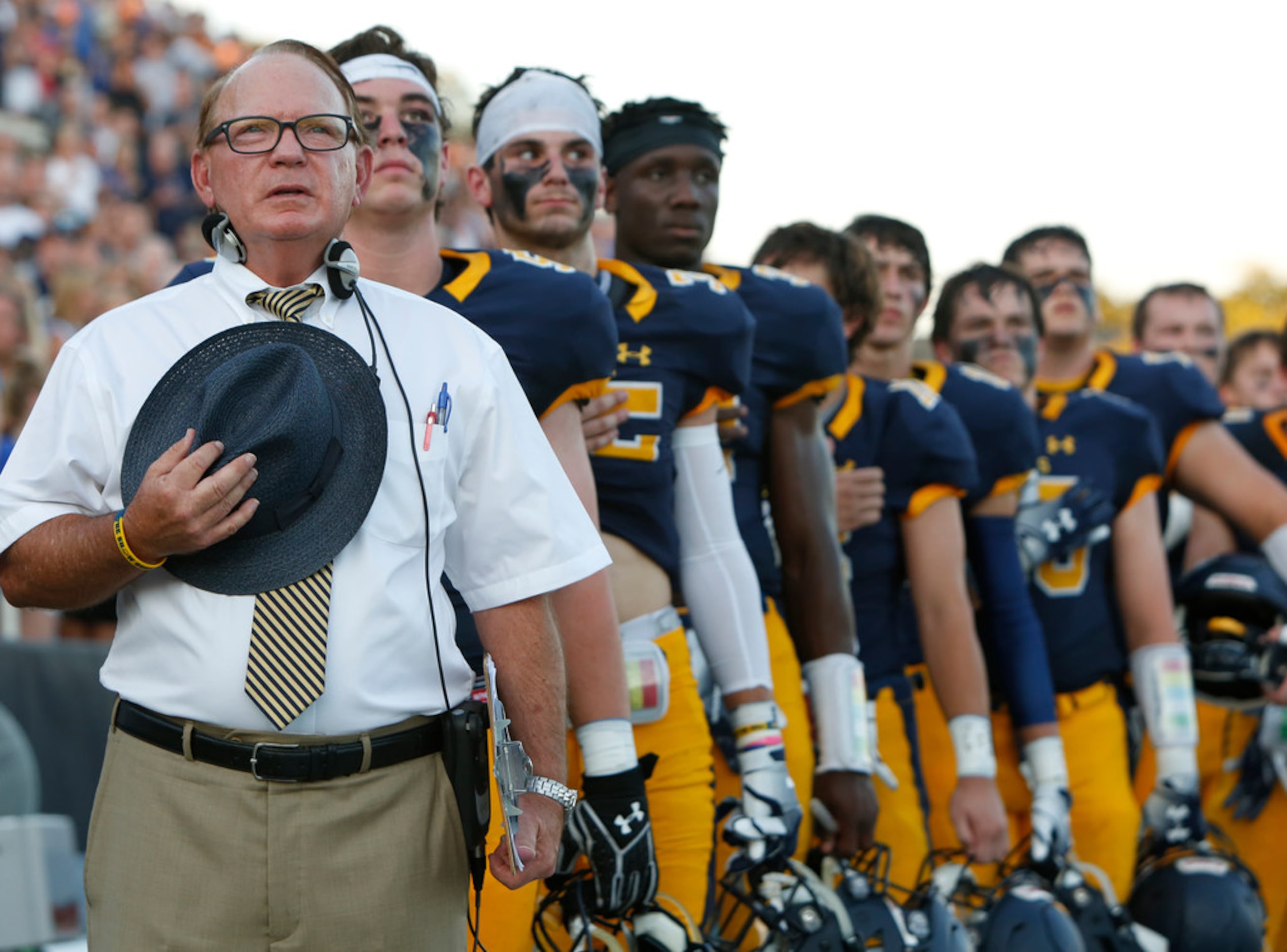 Highland Park head coach Randy Allen stands with his Scots players during the playing of the...