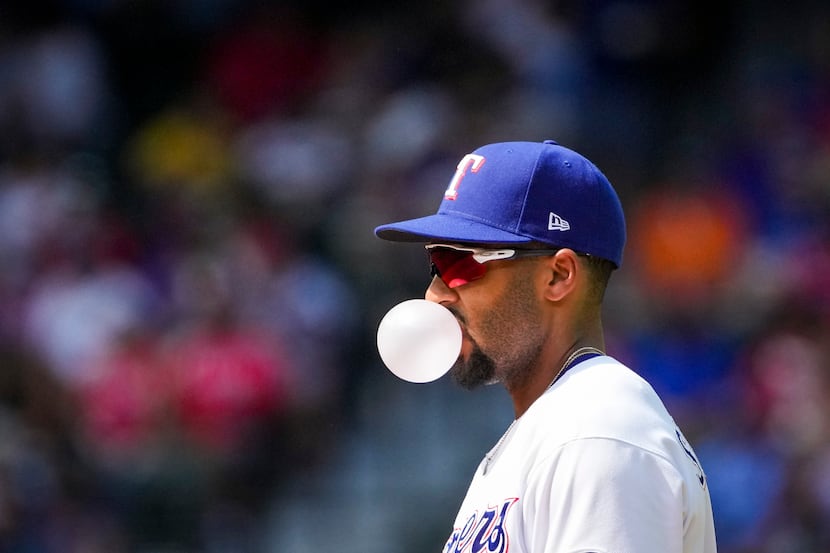 Texas Rangers second baseman Marcus Semien blows bubbles between pitches during the second...