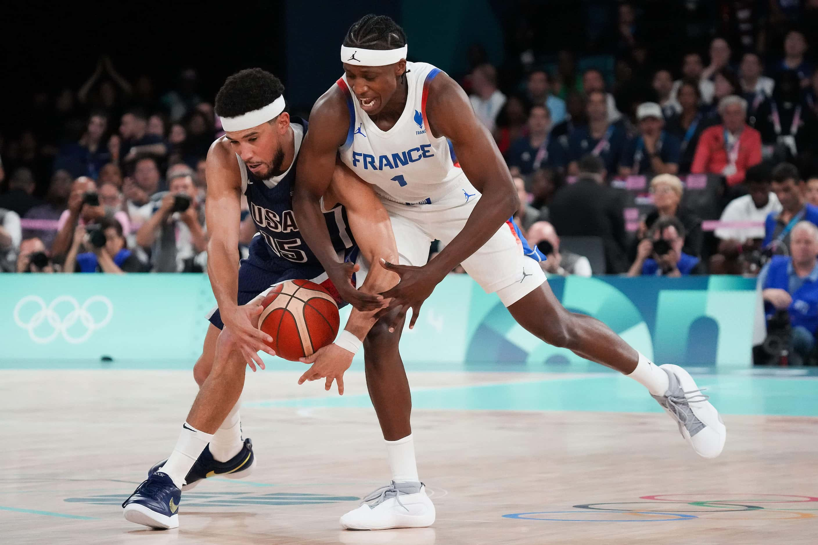 Devin Booker (15) of the United States wrestles the ball away from Frank Ntilikina (1) of...