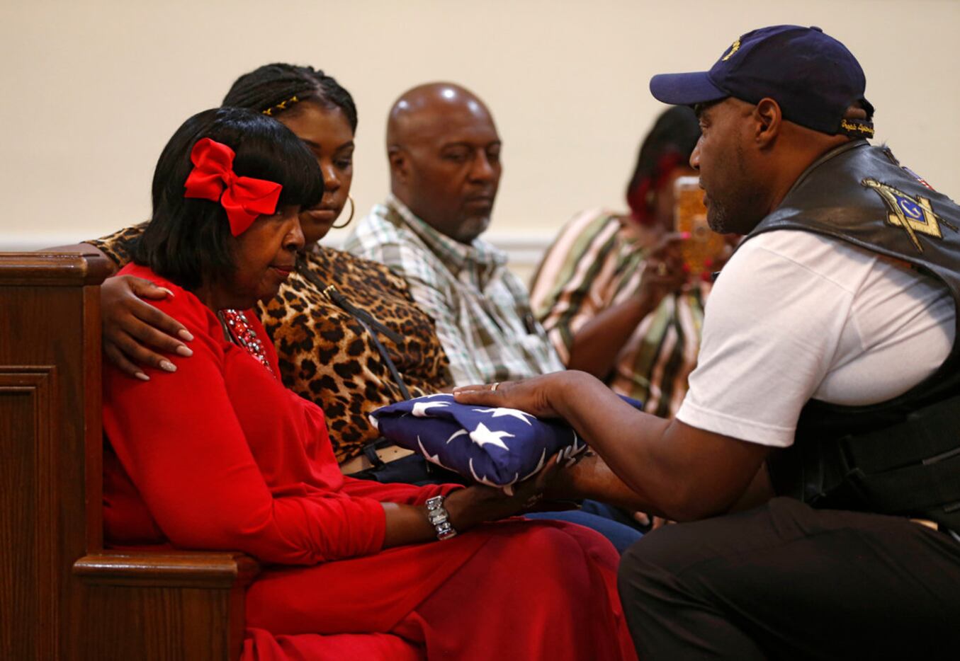 Patriot Guard Ernest Walker hands over the American flag to Daisy Garner, wife of civil...