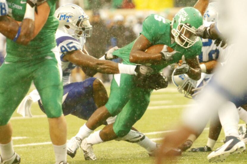 North Texas running back Lance Dunbar (5) fights for yardage as Middle Tennessee defensive...