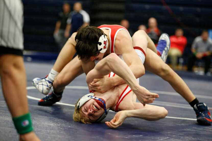 McKinney Boyd's Adam Maestas (top) ties up Allen's Logan Brown during the final round of the...