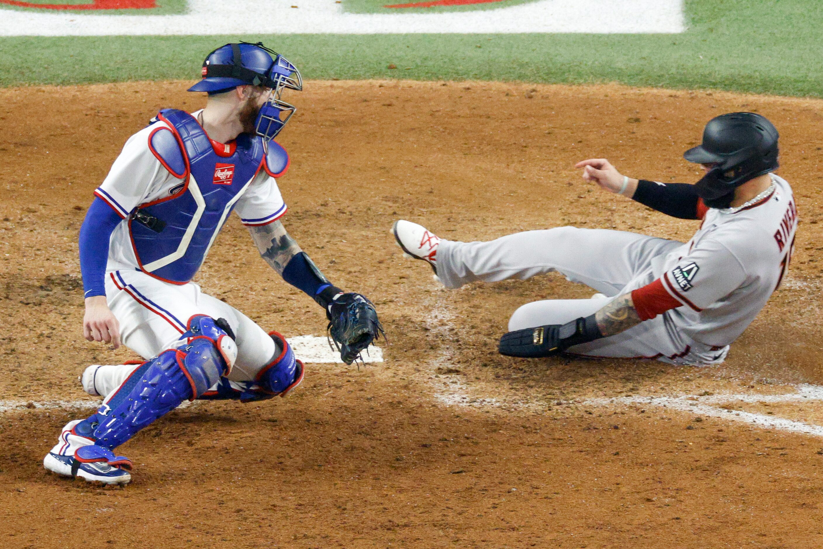 Arizona Diamondbacks third baseman Emmanuel Rivera (15) slides safely across home plate...