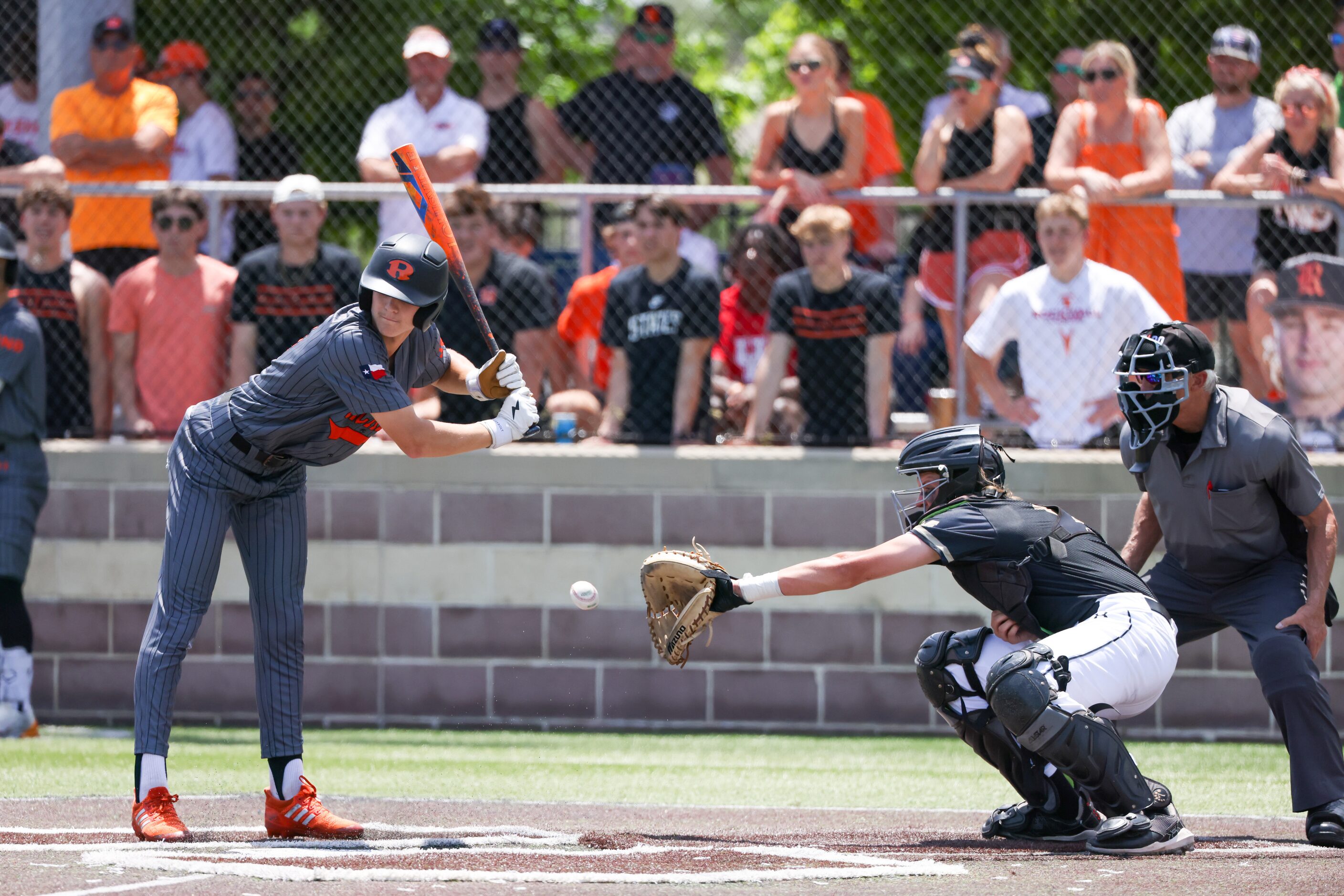 Rockwall sophomore Landyn Locke (4, left) moves back to avoid a ball pitch during an area...