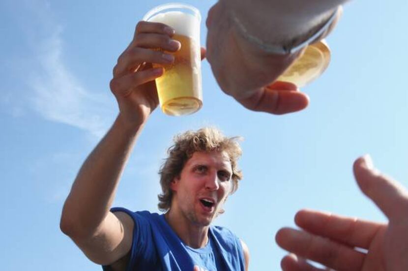 Mavericks forward Dirk Nowitzki holds a cup of beer while he arrives at the Wuerzburg...