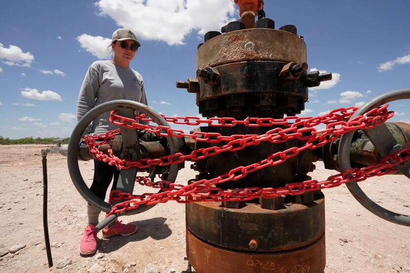 Ashley Williams Watt looks at an abandoned well wrapped with locks and chains on her ranch,...