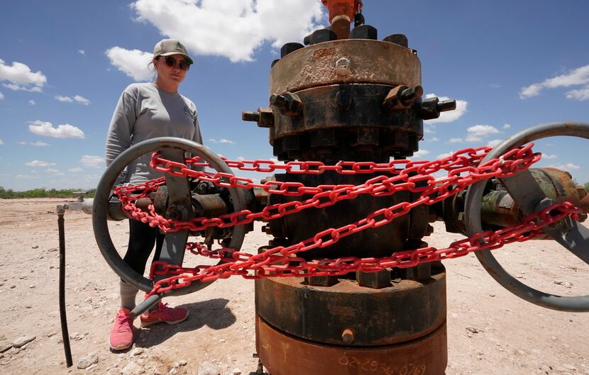Ashley Williams Watt looks at an abandoned well wrapped with locks and chains on her ranch...