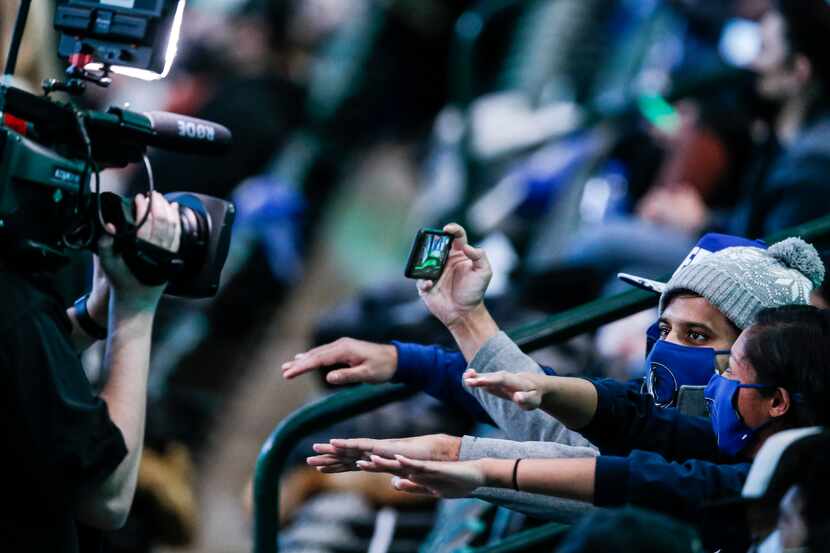 Fans, consisting mostly of healthcare workers, dance for the fan cam during a game between...