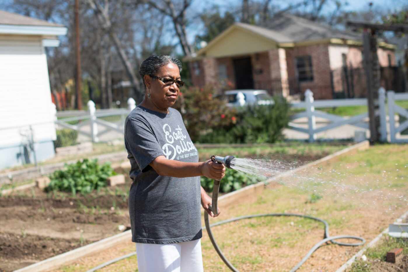Anna Hill tends to the community garden next to her home in the Dallas neighborhood of...