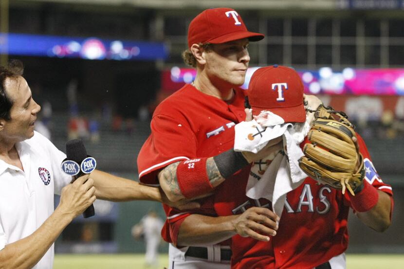 The Rangers' Josh Hamilton (center) puts a to a towel full of shaving cream into the face of...