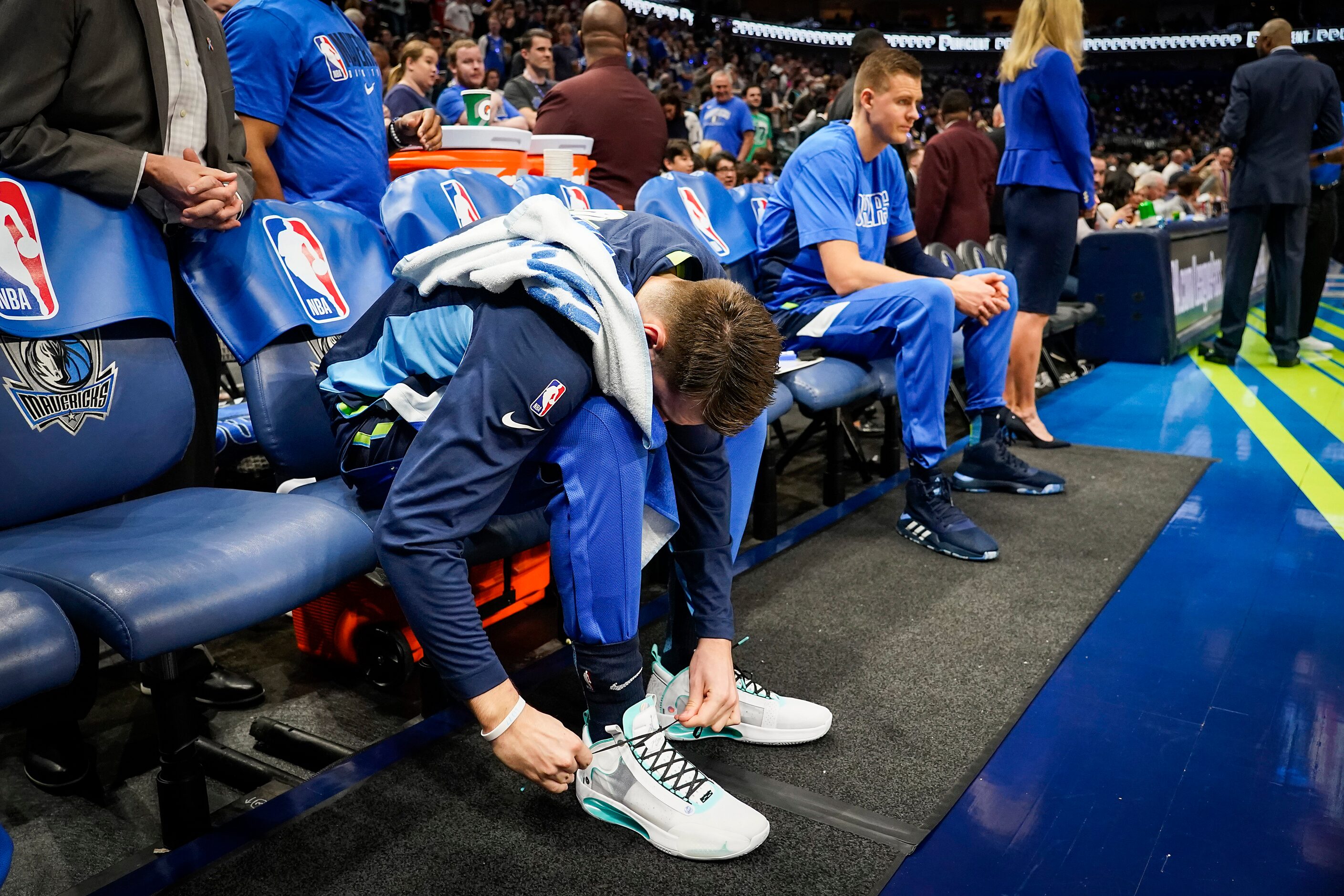 Dallas Mavericks guard Luka Doncic ties his shoes as he prepares to take the court before...