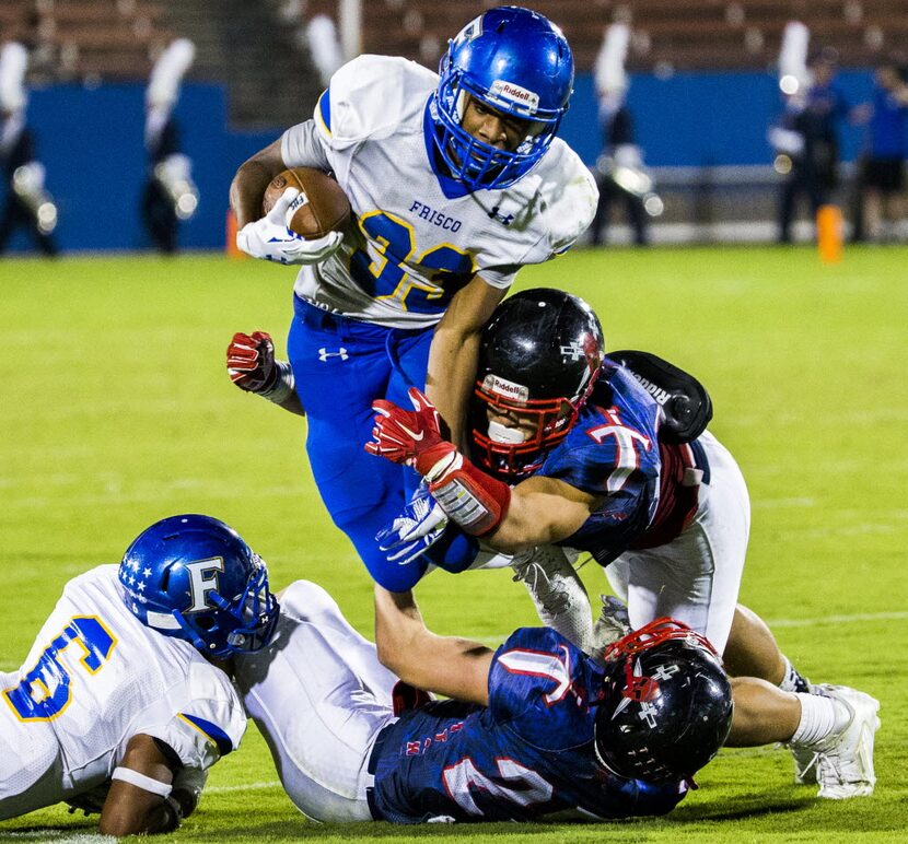 Frisco fullback Idrees Ali (33) is tackled by Frisco Centennial linebacker Alec Melkovitz...