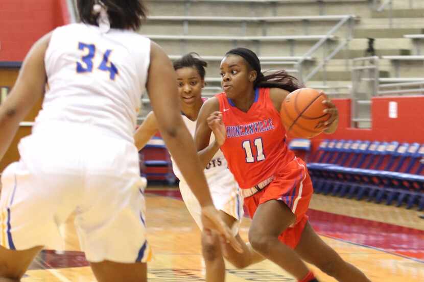 Duncanville guard Chrineisha Davis (11) drives to the basket between two Garland Lakeview...