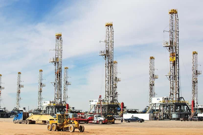 
As the oil glut settles in, idle rigs line up in a drilling company’s yard in West Texas’...