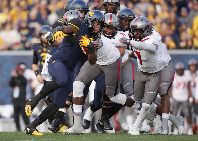 West Virginia running back Wendell Smallwood (4) is tackled by Texas Tech defensive lineman...