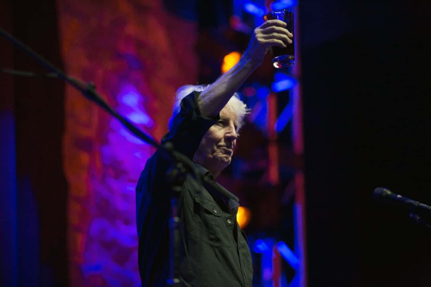 Graham Nash holds up his drink once he joins the stage at Granada Theater in Dallas, Texas,...