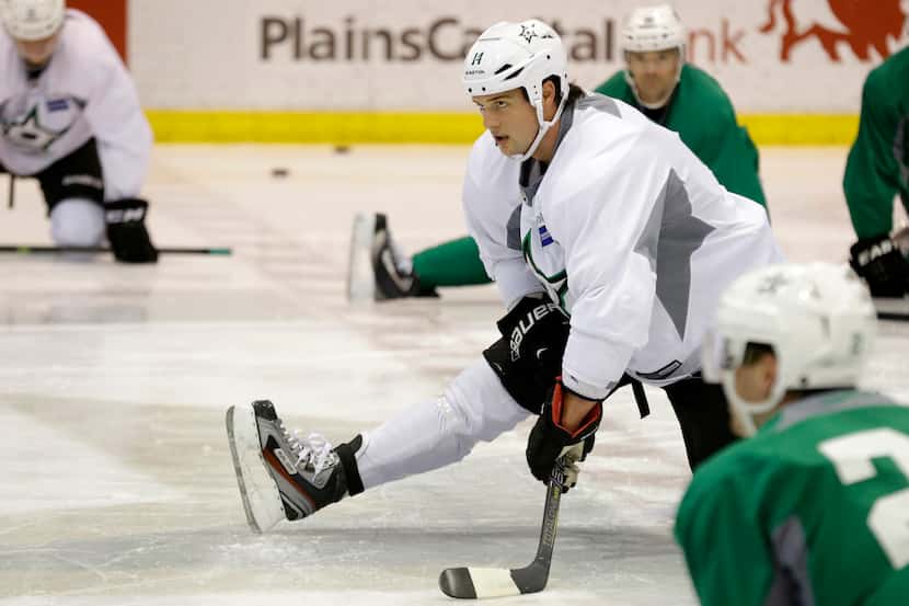Dallas Stars left wing Jamie Benn (14) stretches with teammates during NHL hockey training...
