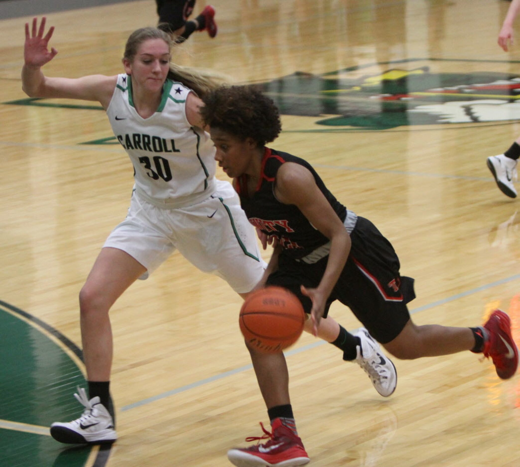 Euless Trinity guard Haleigh Talbert (21) drives past the defense of Southlake Carroll's...