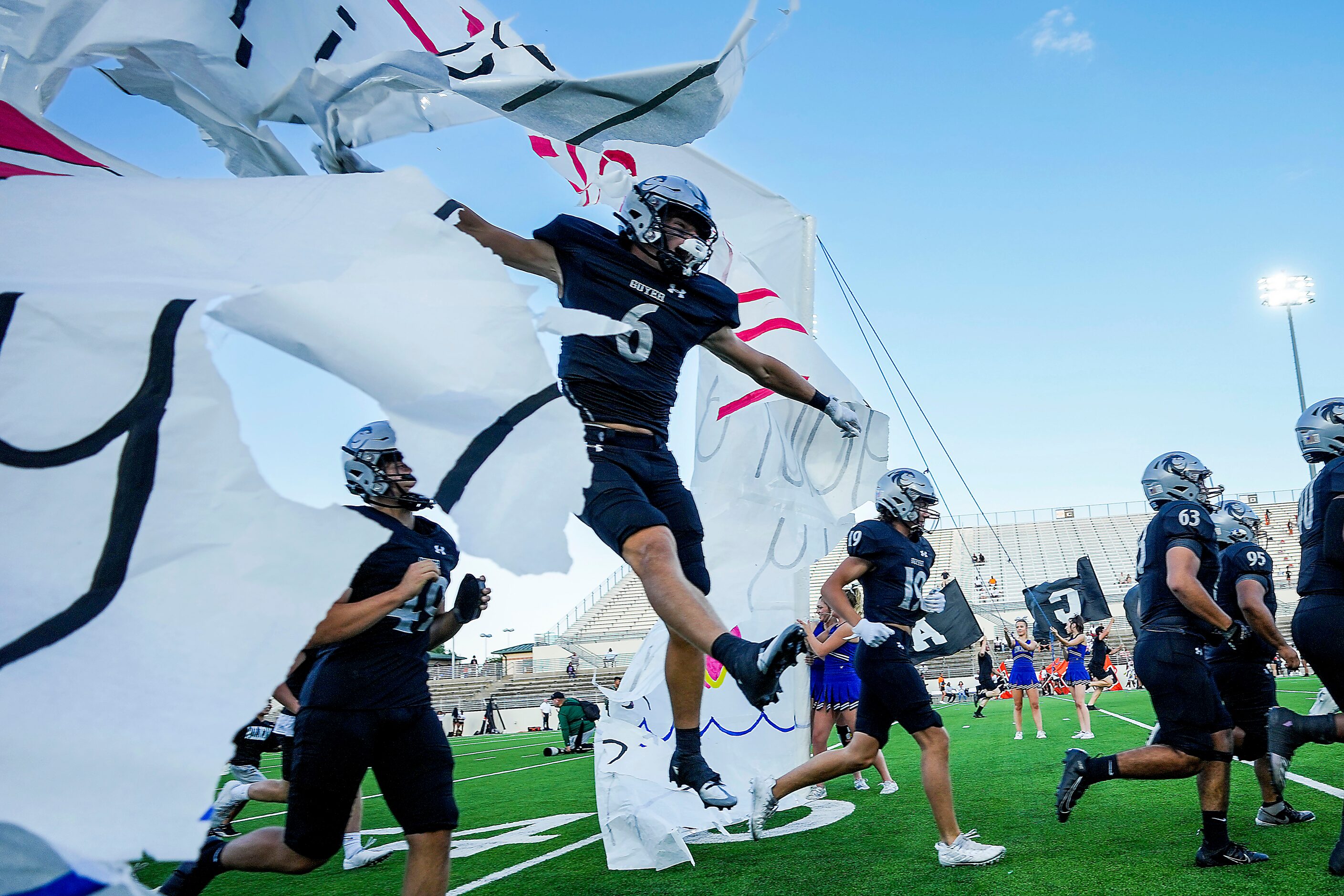 Denton Guyer wide receiver Kegan Stelmazewski (6) flies through the banner as the team takes...