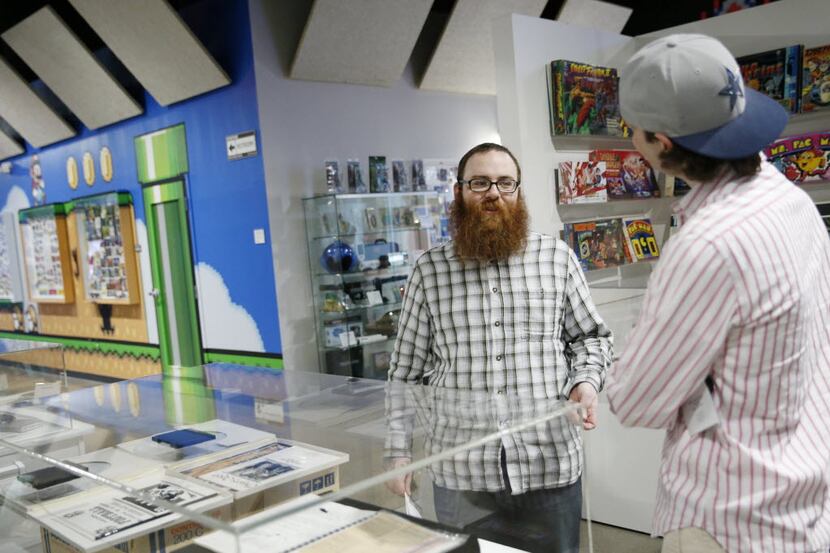 Dustin Fields (center) speaks with Jonathan Carruthers, both of Dallas, about video game...