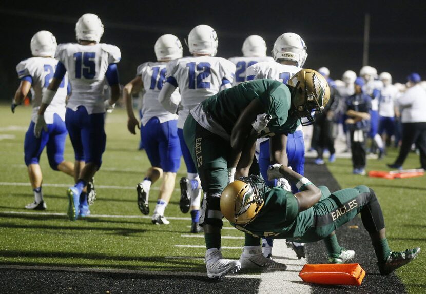 DeSoto running back Kelan Walker (34) is lifted by offensive lineman Xavier Newman (55)...