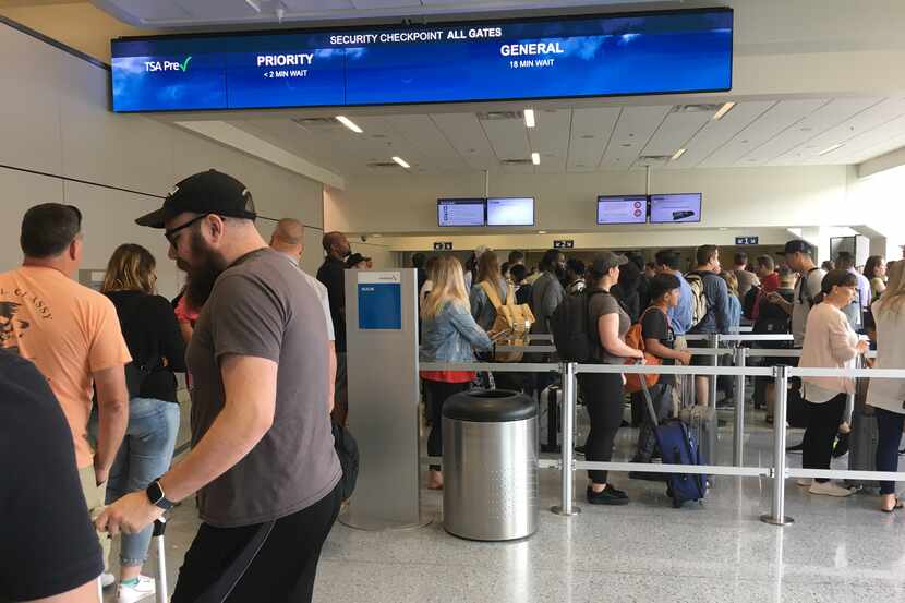 Travelers wait in crowded lines at DFW Airport Monday morning.