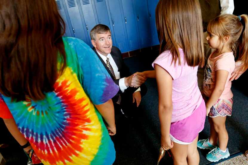Tom Trigg, outgoing superintendent of Highland Park ISD, greeted Isabel Gameros, 9, and her...