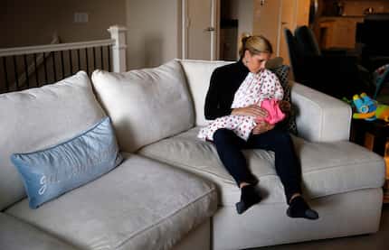 Jenny Boucek breastfeeds her 4-month-old daughter, Rylie, at her home in Dallas on Tuesday,...