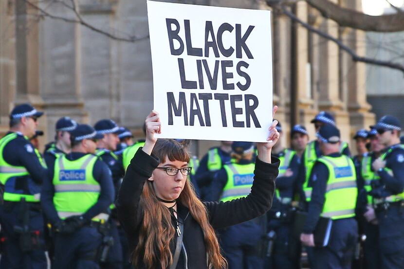 A woman holds a Black Lives Matter placard.