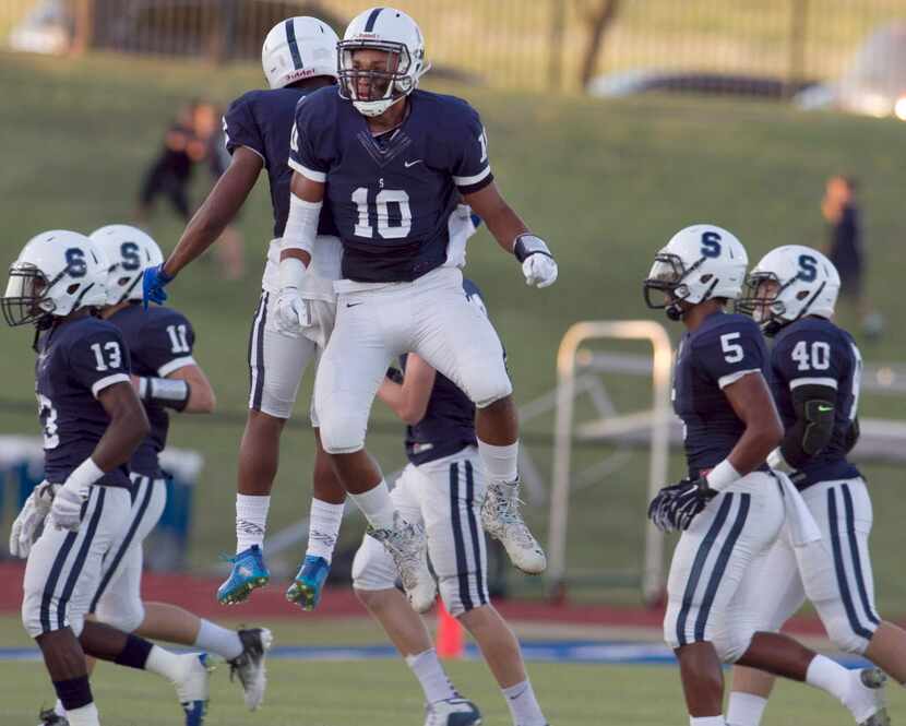 Fort Worth All Saints safety Quincy Jones (10) celebrates with Isaiah Harris (2) following...