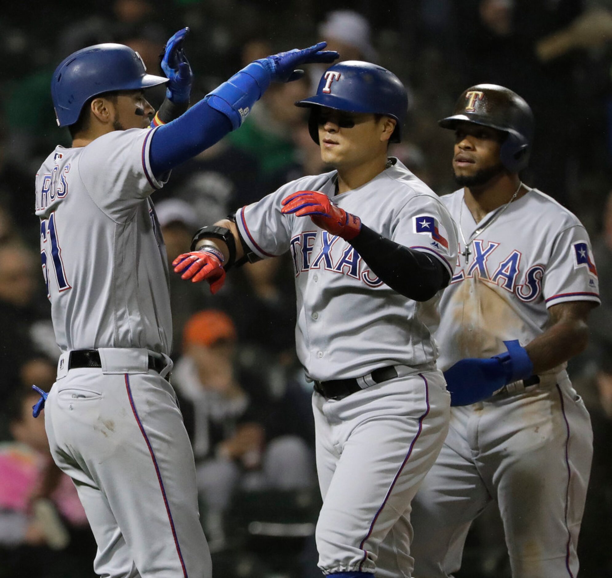 Texas Rangers' Shin-Soo Choo, center, of South Korea, celebrates with Robinson Chirinos,...