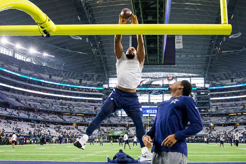 Dallas Cowboys tight end Rico Gathers tries to dunk the ball over the goalpost while warming...