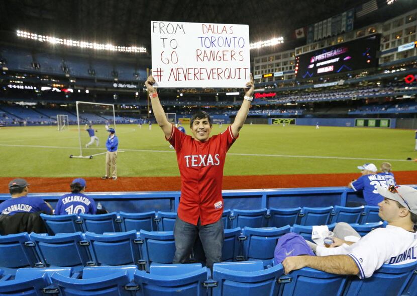 Ernesto Rojas of Dallas came ready to cheer on the Rangers as he looks for his seats along...