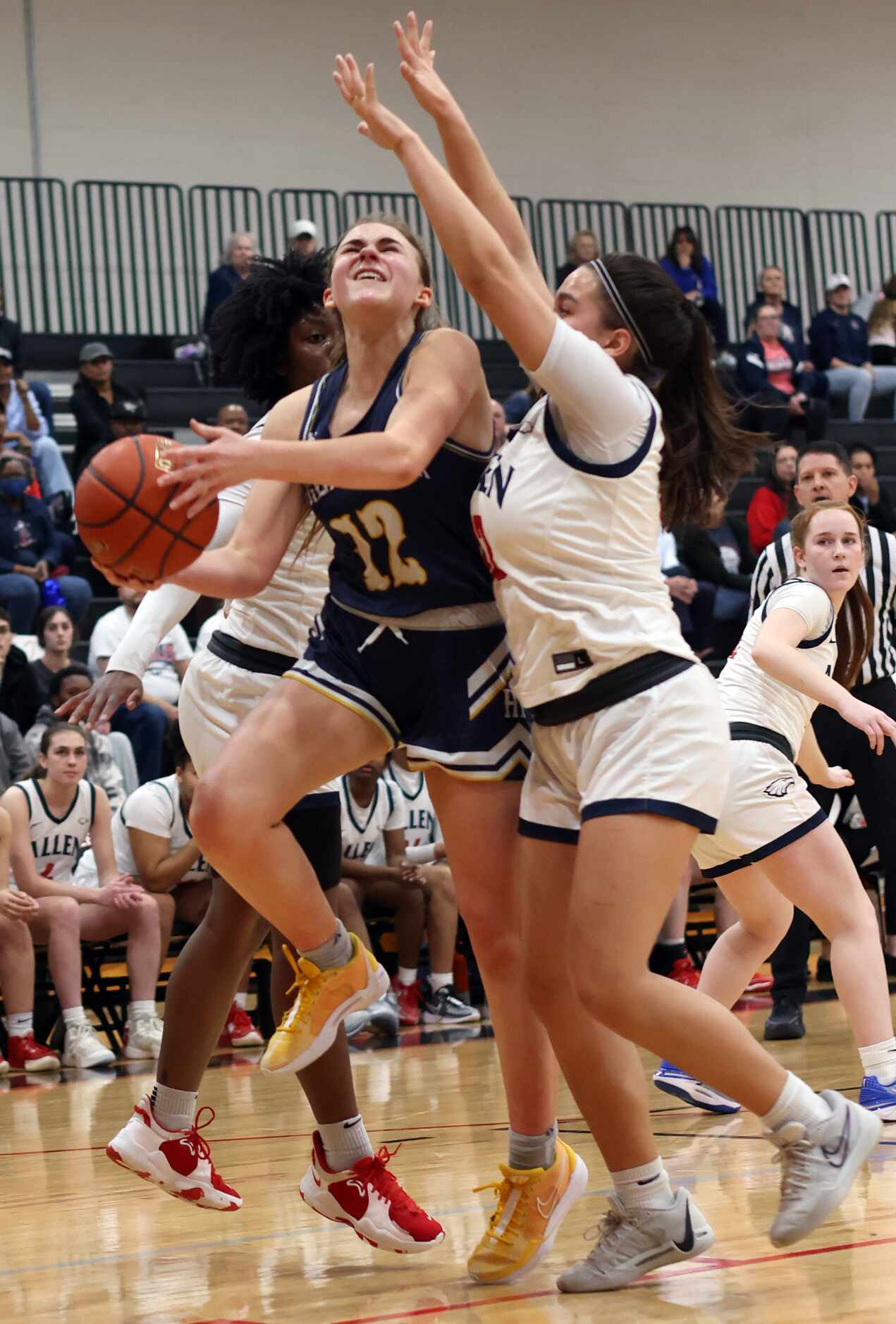 Highland Park guard Ali Jackson (12) drives to the basket as she is defended by Allen's...
