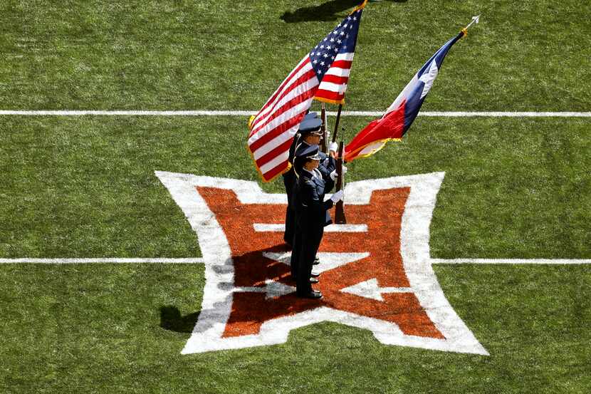 The color guard stands on the Big 12 logo for the playing of the national anthem at...