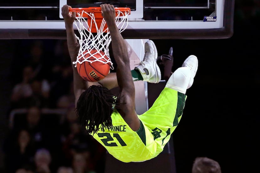 Baylor forward Taurean Prince hangs from on a dunk against Yale during the first half in the...