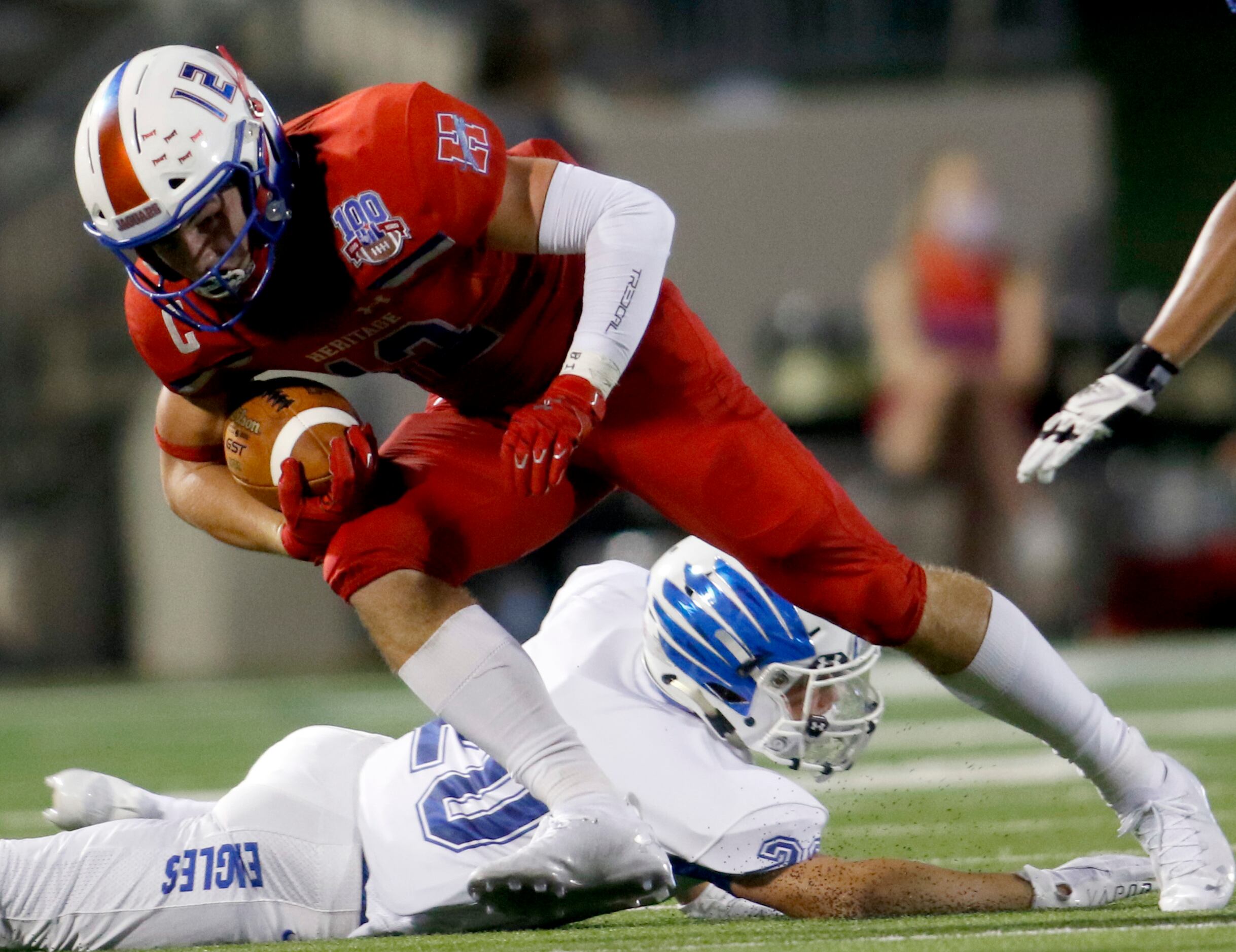 Midlothian Heritage receiver Haydon Wigginton (12) lunges for extra yardage as he side steps...