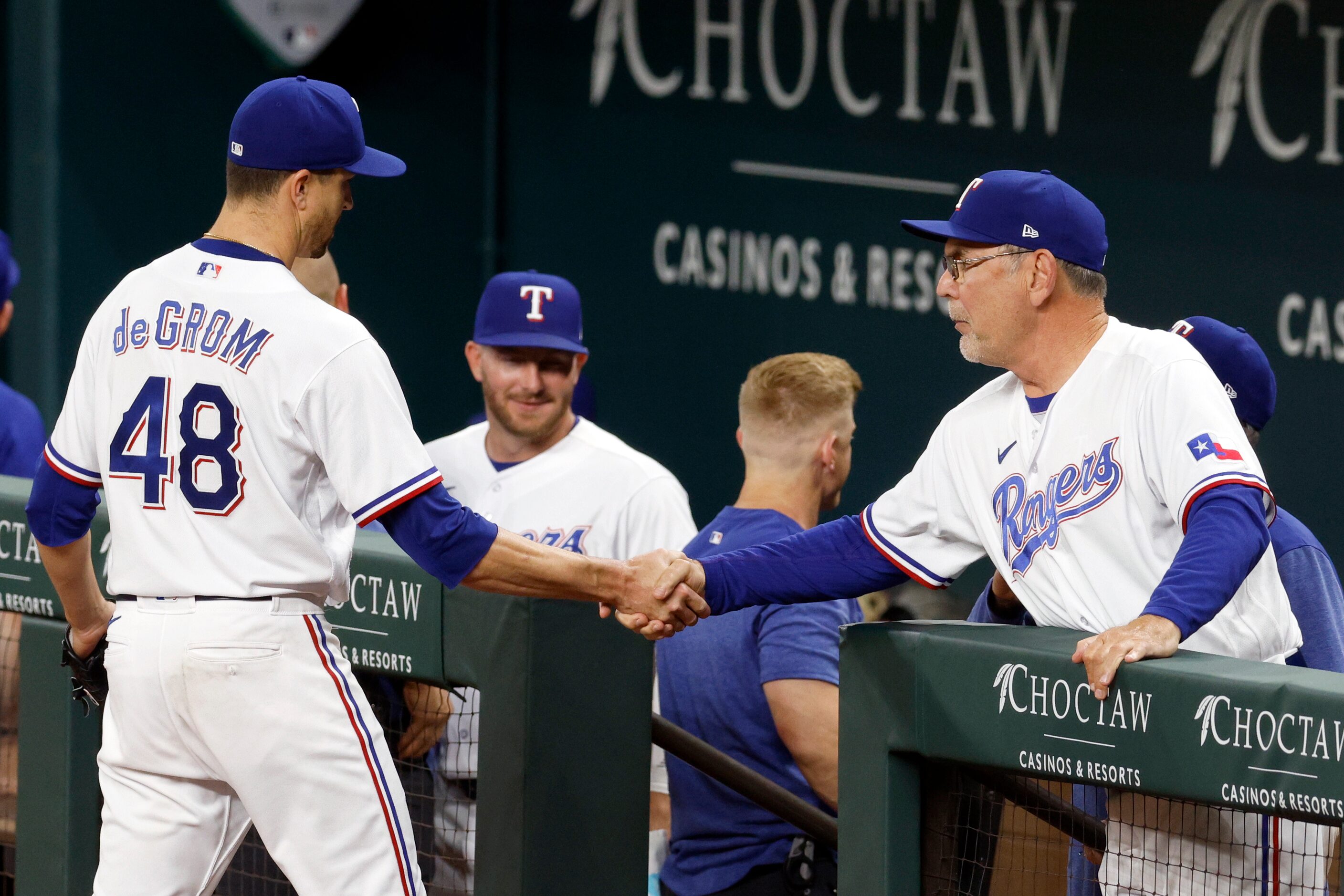 Texas Rangers starting pitcher Jacob deGrom (48) shakes hands with manager Bruce Bochy (15)...