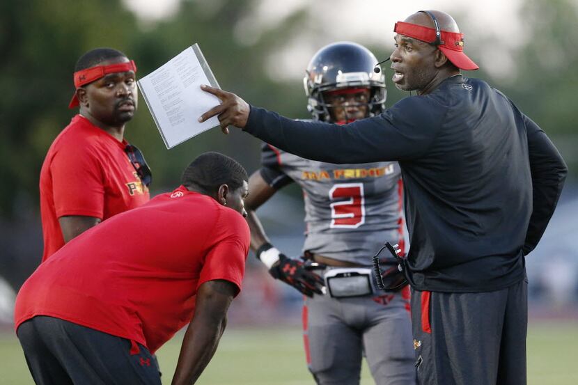 AAA Prime U coach Deion Sanders speaks to his players during a high school football game...