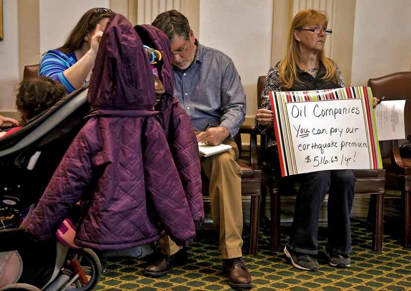 Shirley Herkert holds  a sign protesting the earthquake insurance premiums she has to pay.