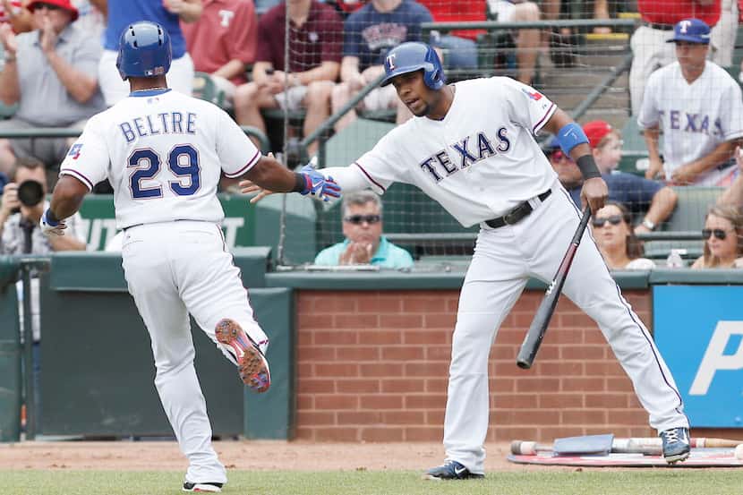 Texas Rangers' Adrian Beltre (29) is congratulated by teammate Elvis Andrus after scoring a...