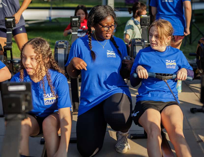 Amaya Strickland, 14, (left) and Carson Mayerso, 14, (right) learn from Janice Otieno about...