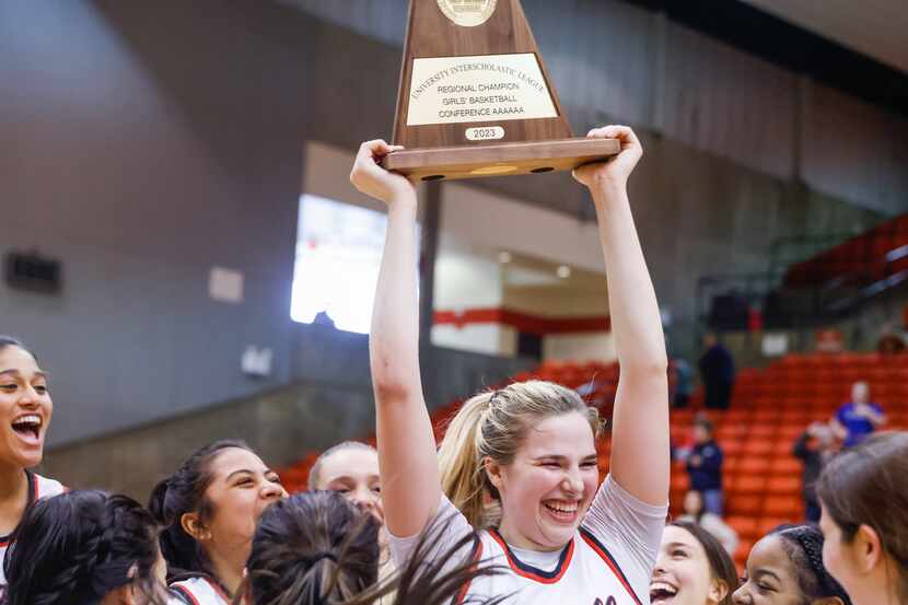 Coppell senior guard Julianna LaMendola (20) raises the team’s trophy above her teammates...