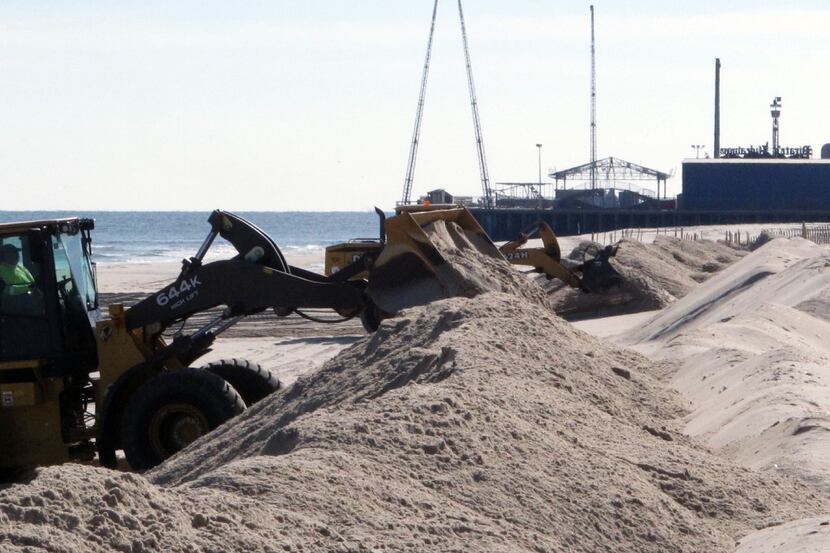 This Jan. 21, 2016 photo shows front end loaders shoring up a badly eroded section of beach...