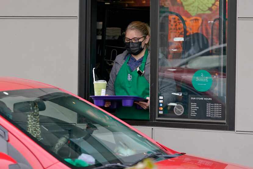 A barista served up a drink in the drive-through lane at a Starbucks Coffee store in south...